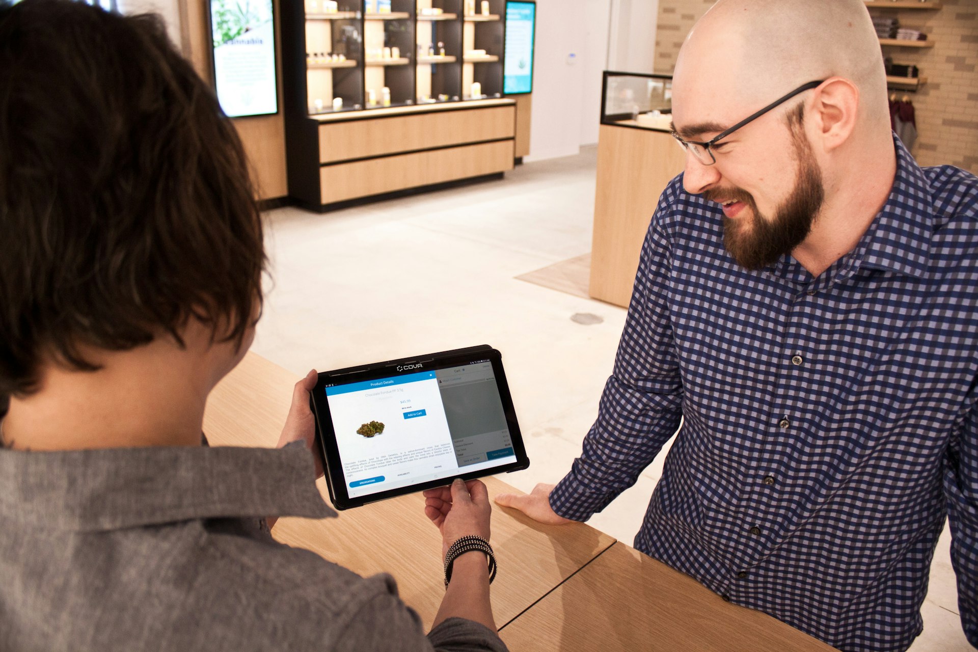 a man showing a tablet to a woman in a store